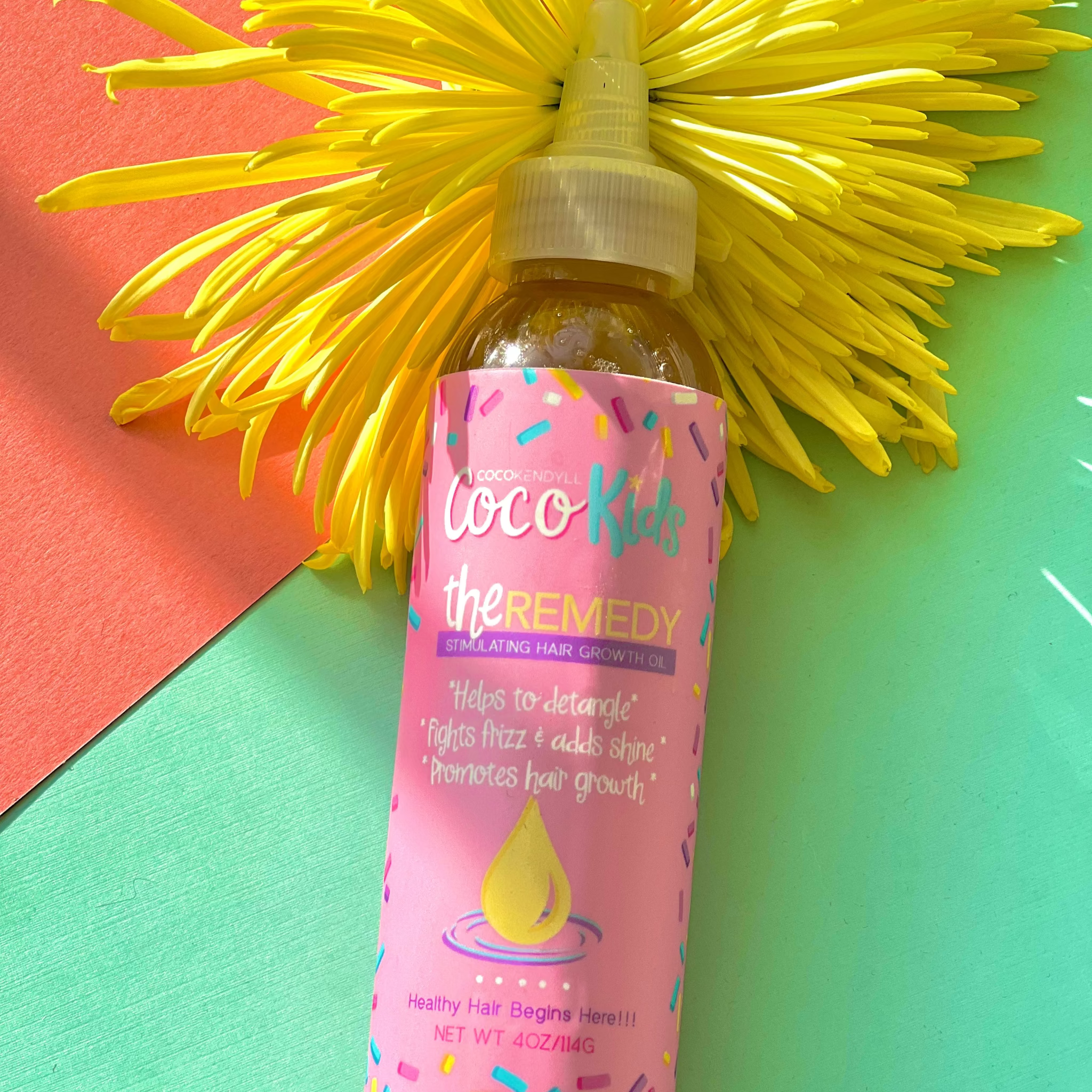 Coco Kendyll Kids Remedy Growth Oil bottle with yellow flower background gentle scalp and hair oil for children