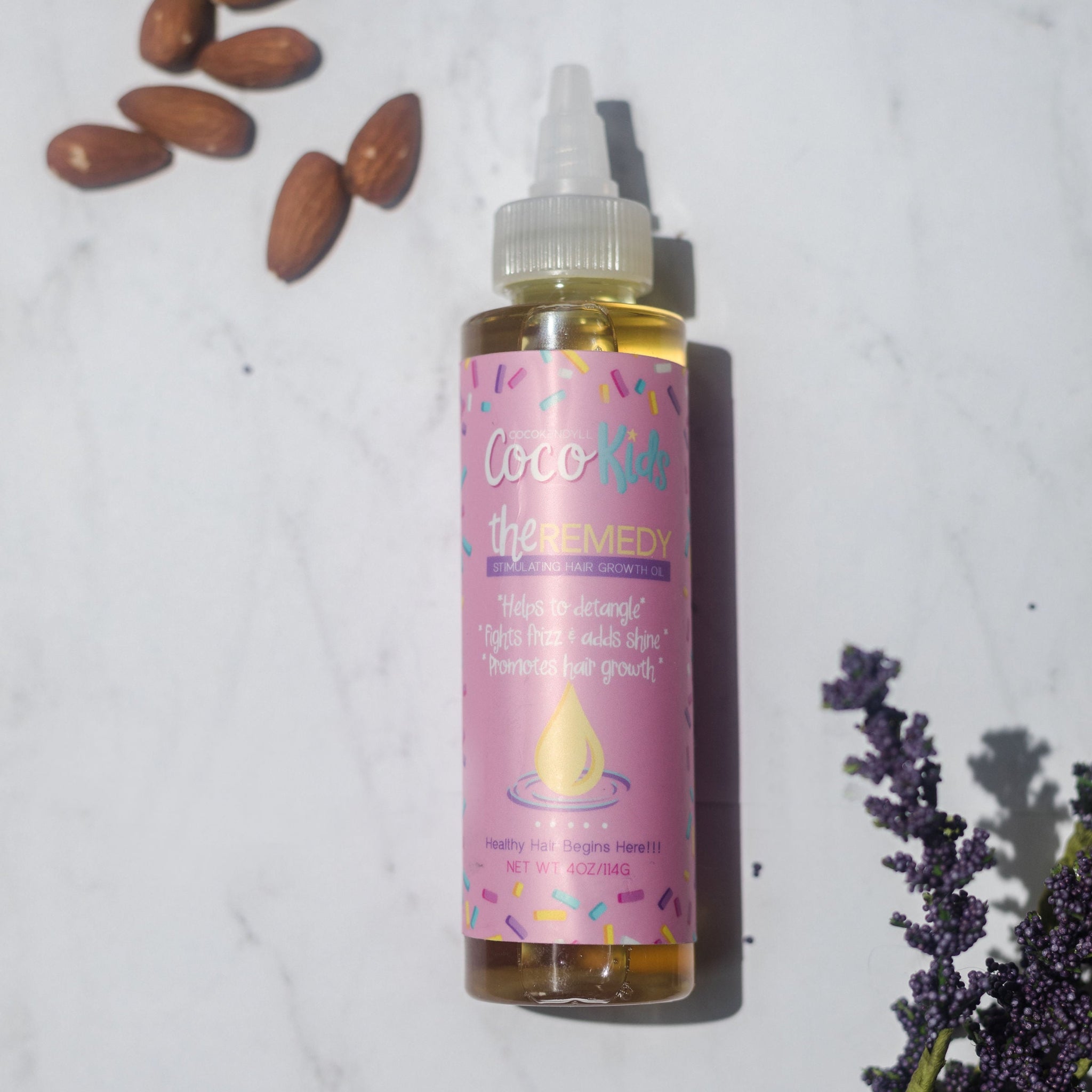 Coco Kedyll Kids Remedy Growth Oil bottle styled with almonds and lavender, gentle scalp and hair oil for children